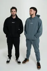 Pantalón de jogging negro con elástico en la cintura y logo 'Sosi' estampado en blanco en la pierna izquierda.