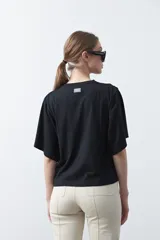 Remera blanca de manga corta con bordado frontal en azul que dice "dolce far niente the sweetness of doing nothing". Tiene un calce relajado.