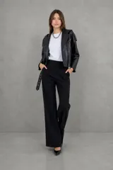 Campera estilo motoquera de cuero sintético negro, con capucha integrada, cierre frontal, bolsillos laterales con cierre y cinturón ajustable en la cintura.