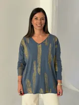 Sweater de punto color azul jean con estampado de pinceladas doradas brillantes, cuello en V y mangas largas.