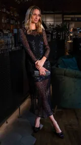 Vestido largo negro de lentejuelas con mangas largas y corte ajustado.