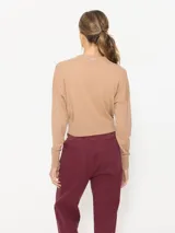 Sweater gris de lana merino con cuello redondo cerrado y mangas largas.