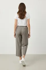Pantalon de corte holgado con diseño de rayas verticales negras sobre fondo blanco, presenta cintura elástica.