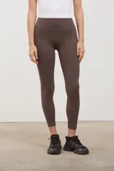 Calza deportiva de tiro alto con compresión media, confeccionada en tejido suave y elastizado sin costuras en el frente.