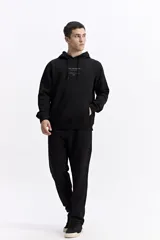 Canguro oversize de algodón, color negro, con capucha ajustable, bolsillo frontal tipo canguro y estampa sutil en el pecho.