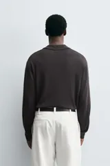 Polo de punto de manga larga con cuello solapa y abertura frontal, confeccionado en tejido de viscosa con acabado en rib.