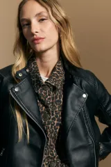Campera negra de cuero sintético estilo biker, con cierre asimétrico, broches metálicos en el cuello y bolsillos con cierre.