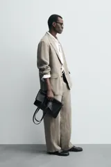 Pantalón de corte straight relaxed fit confeccionado en tejido de lino con efecto lavado. Presenta cierre frontal con cremallera y botón, bolsillos laterales y bolsillos traseros de vivo.