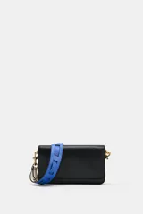 Bolso bandolera rectangular de color negro con solapa y cierre de botón imantado, herrajes metálicos dorados y compartimento interior con cremallera. Incluye una correa ancha ajustable y extraíble en combinación de colores azul y blanco.