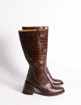 Botas de caña media de cuero vacuno color negro, con cierre lateral interno, taco de madera forrado en cuero y suela de goma.