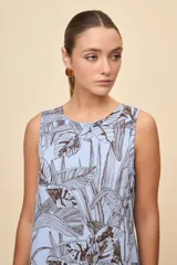 Vestido corto sin mangas de color celeste con estampado botánico en tonos marrones, de silueta amplia, escote redondo y volado en el ruedo.