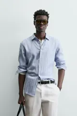 Camisa de hombre de manga larga, cuello italiano y corte regular fit, confeccionada en tejido de lino a rayas verticales azules y blancas.