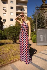 Vestido largo de tul con estampado de cuadrados de terciopelo multicolor, cuello halter atado a la nuca y aberturas laterales en la cintura.
