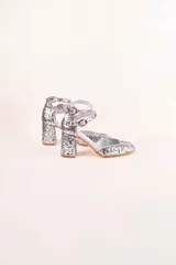 Zapato de tacón plateado con glitter, punta cuadrada, doble tira con hebilla al tobillo y forro rosa.