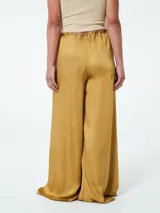 Pantalón negro de tela satinada, corte palazzo, cintura alta con elástico y lazo ajustable.