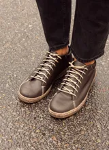 Zapatillas acordonadas de cuero color chocolate oscuro, con suela cosida y cordones color crema.