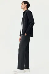 Pantalón tipo jogger de vestir con pliegues frontales y traseros, cintura elástica con cordón de ajuste, bolsillos laterales al bies y bolsillos traseros insertados. Presenta un corte slim fit entallado.