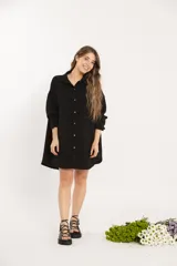 Camisa negra oversize de manga larga con cuello camisero y cierre frontal con botones.