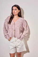 Cardigan de punto texturado en color rosa viejo, con escote en V, cierre frontal de botones y mangas largas con puños acanalados.