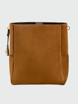 Bolso tipo cubo de gamuza en color marrón, con asa de hombro ajustable y detalle de dije metálico colgante.