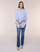 Sobrecamisa holgada de algodón liviano, con estampado de rayas verticales en tonos azul y blanco, diseño oversize, cuello solapa, mangas largas ajustables con presilla y ruedo curvo.