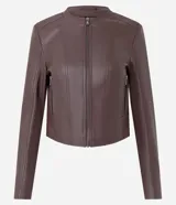 Campera básica de poliuretano color marrón, de corte corto, cuello redondo y manga larga. Cuenta con cierre frontal y bolsillos laterales con cremallera, además de detalles de recortes pespunteados.
