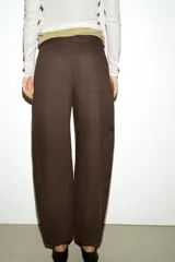 Pantalón de tiro medio con diseño barrel, pernera holgada que se estrecha hacia el tobillo, bolsillos delanteros y bolsillos de plastrón en la espalda. Confeccionado en tejido con textura de espiga, cuenta con cierre frontal de cremallera, botón interior y gancho.