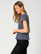 Remera blanca de manga corta con cuello redondo, confeccionada en una mezcla de modal, poliéster y elastano. Presenta un diseño con alforzas verticales en el frente que aportan estructura y una silueta relajada.