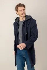 Chaquetón de lana color azul marino, con diseño de doble capa que incluye una capucha integrada y cierre frontal. Presenta solapas clásicas y corte recto.