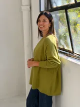 Sweater de punto color verde pistacho, con cuello redondo, mangas largas con puños ajustados y diseño holgado de corte oversize.