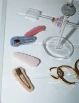 Set de dos broches para el pelo forrados en tela símil piel, uno color beige y otro color rosa.