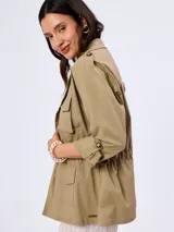 Campera cazadora de estilo safari color verde militar, con múltiples bolsillos con solapa en el frente, cuello solapa y cordón ajustable en la cintura.