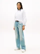 Zapatillas de piel napa blanca con detalles en tonos rosados y durazno. Presentan una silueta clásica de corte bajo con cierre de cordones, insignia del monograma TH metalizada en el lateral y suela de goma blanca finamente dentada.