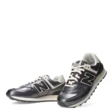 Championes urbanos New Balance modelo 574, color gris metalizado con detalles en color natural. Presentan el logo N característico en los laterales, cordones al tono y suela con tecnología ENCAP.