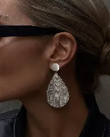 Aros colgantes de diseño geométrico en forma de gota, con acabado plateado y textura de ondas grabadas en relieve. Cuentan con un cierre de perno circular liso.