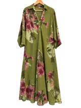 Vestido largo color verde pistacho con estampado floreado en tonos rosados, escote en V con cuello camisero, cierre frontal con botones y mangas tres cuartos acampanadas.