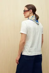 Remera color rosa pálido de manga corta confeccionada en algodón liviano con textura sutil y terminaciones al ruedo con pequeños tajos laterales.