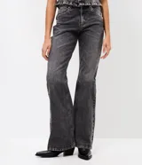 Pantalón de jean con corte flare, tiro medio y efecto desgastado. Presenta cierre frontal con botón, pasantes para cinturón y bolsillos traseros con solapa.