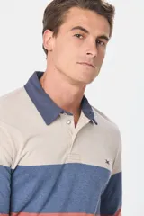 Remera tipo polo de manga larga con diseño de franjas horizontales en tonos azul marino, celeste, verde agua y gris. Presenta cuello clásico con cierre de botones y puños elásticos.