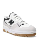 Championes urbanos New Balance modelo 550, color blanco con detalles en negro y gris, confeccionados en cuero sintético y textil, con logo "N" característico en los laterales y suela de goma color caramelo.