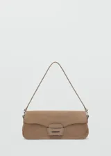 Bolso de hombro tipo baguette confeccionado en piel de serraje color tostado. Presenta un diseño rectangular con solapa frontal decorada con un detalle metálico y pespuntes visibles. Incluye un asa fija y forro interior.