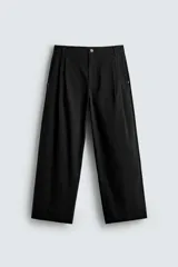Pantalón chino de corte wide fit confeccionado en tejido de algodón. Presenta pliegues frontales, bolsillos laterales y bolsillos traseros de vivo, con cierre frontal de cremallera y botón.