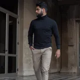 Polera de cuello alto confeccionada en tejido de algodón con spandex, de corte ajustado, con puños y ruedo acanalados.