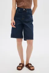Bermuda de jean azul de tiro alto, corte boyfriend con bolsillos y terminaciones deshilachadas.