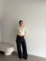 Pantalón de jean negro de tiro alto y corte wide leg, con diseño amplio y dobladillo ancho vuelto hacia arriba.
