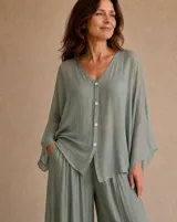 Camisa verde agua de corte holgado y semitransparente, con escote en V y cierre frontal de botones. Presenta mangas anchas y diseño fluido.