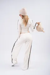 Pantalón tipo palazzo de corte amplio y fluido, color negro, con doble línea lateral blanca y cintura elástica.