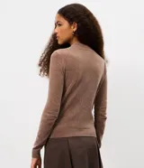 Blusa de manga larga confeccionada en tejido de chenille, con cuello alto y ajuste al cuerpo.