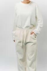 Pantalón deportivo de corte wide leg con caída relajada. Presenta cintura elastizada con cordón ajustable, bolsillos laterales y un interior frizado para mayor abrigo.