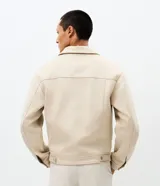 Campera estilo Harrington de corte bomber, confeccionada en material con acabado de gamuza sintética. Presenta cuello con solapa, cierre frontal completo, mangas largas y bolsillos laterales con cierre.